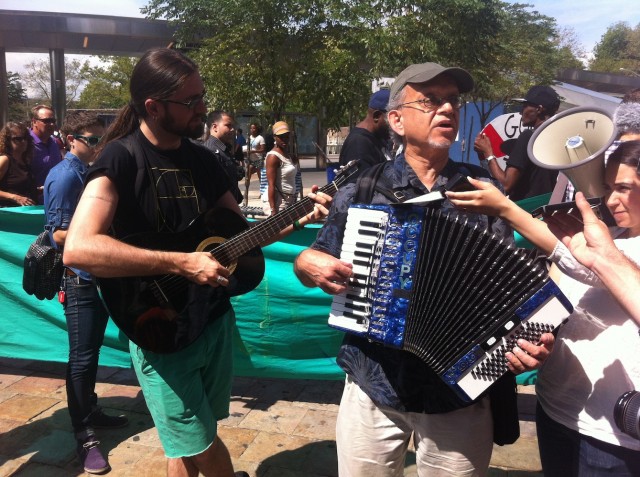 Two-man guitar and accordion band lead group in song before embarking on march
