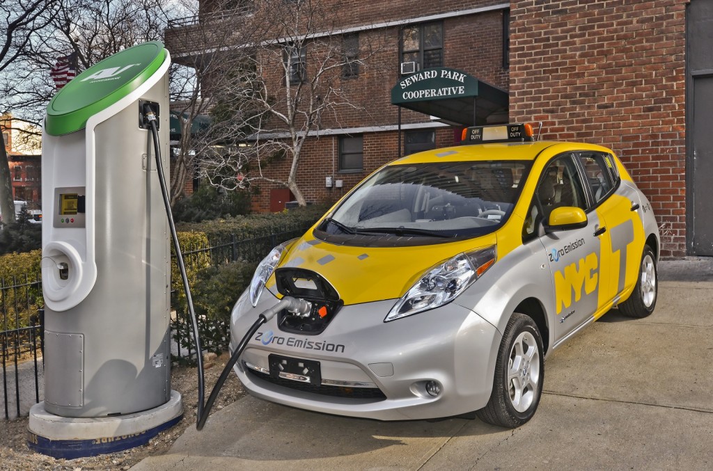 Why aren't we rolling in these already? Nissan Leaf test taxi at a charging station. Photo: Green Car Reports