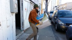 Gibbs carries box of off-grid solar equipment to bring to Roca's studio